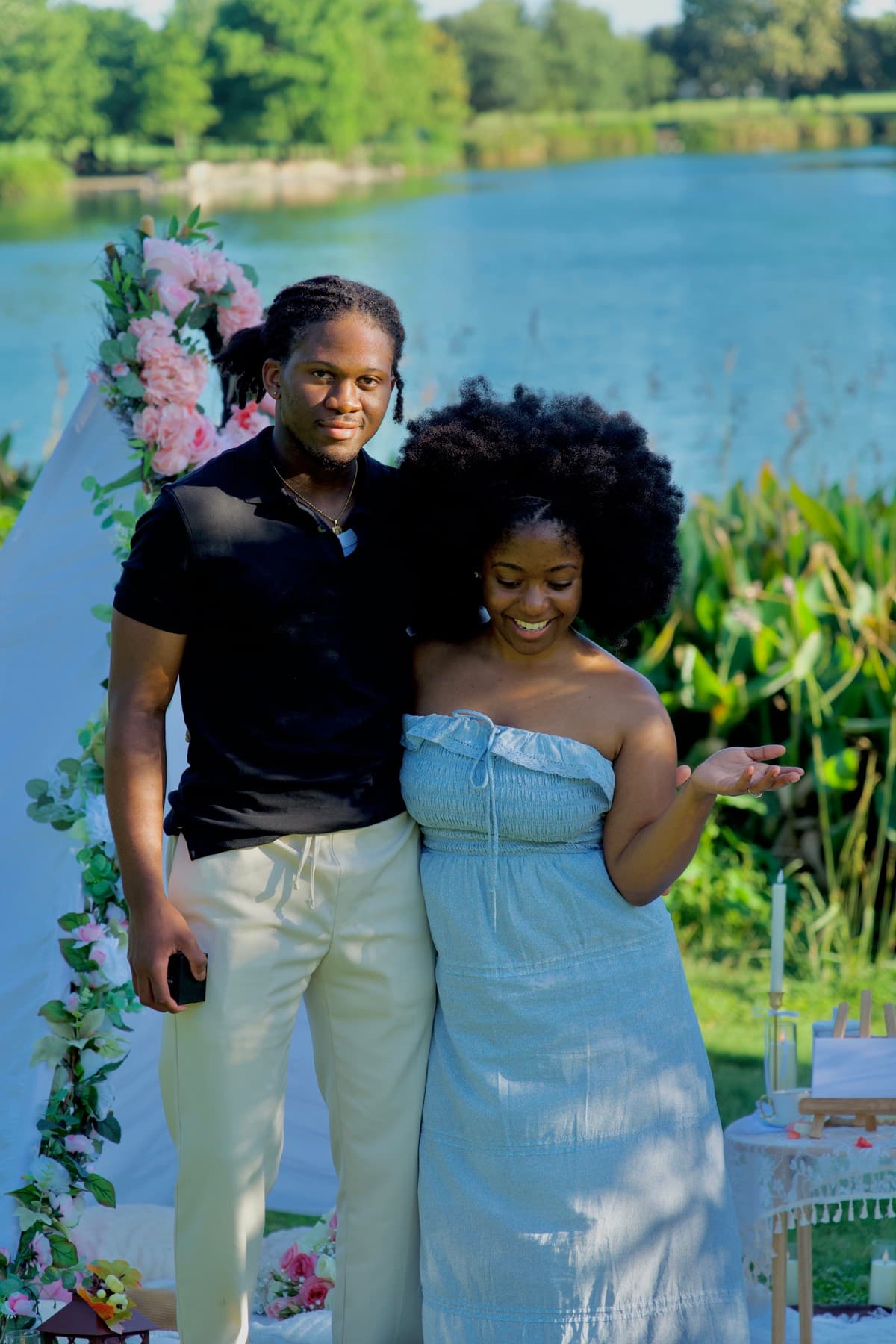 Couple at a lakeside picnic with a flower-draped white tent in Austin