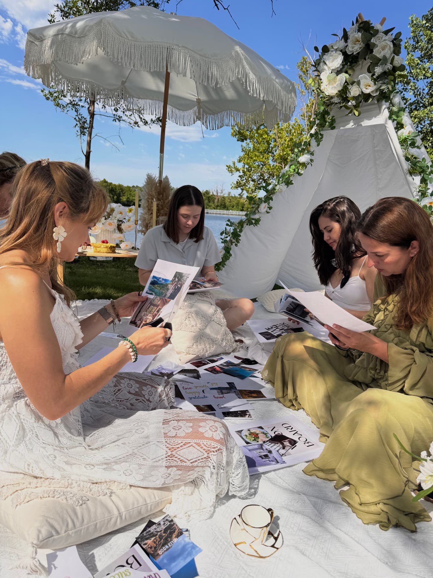 Amigas creando tableros de sueños en un pícnic junto al lago en Austin