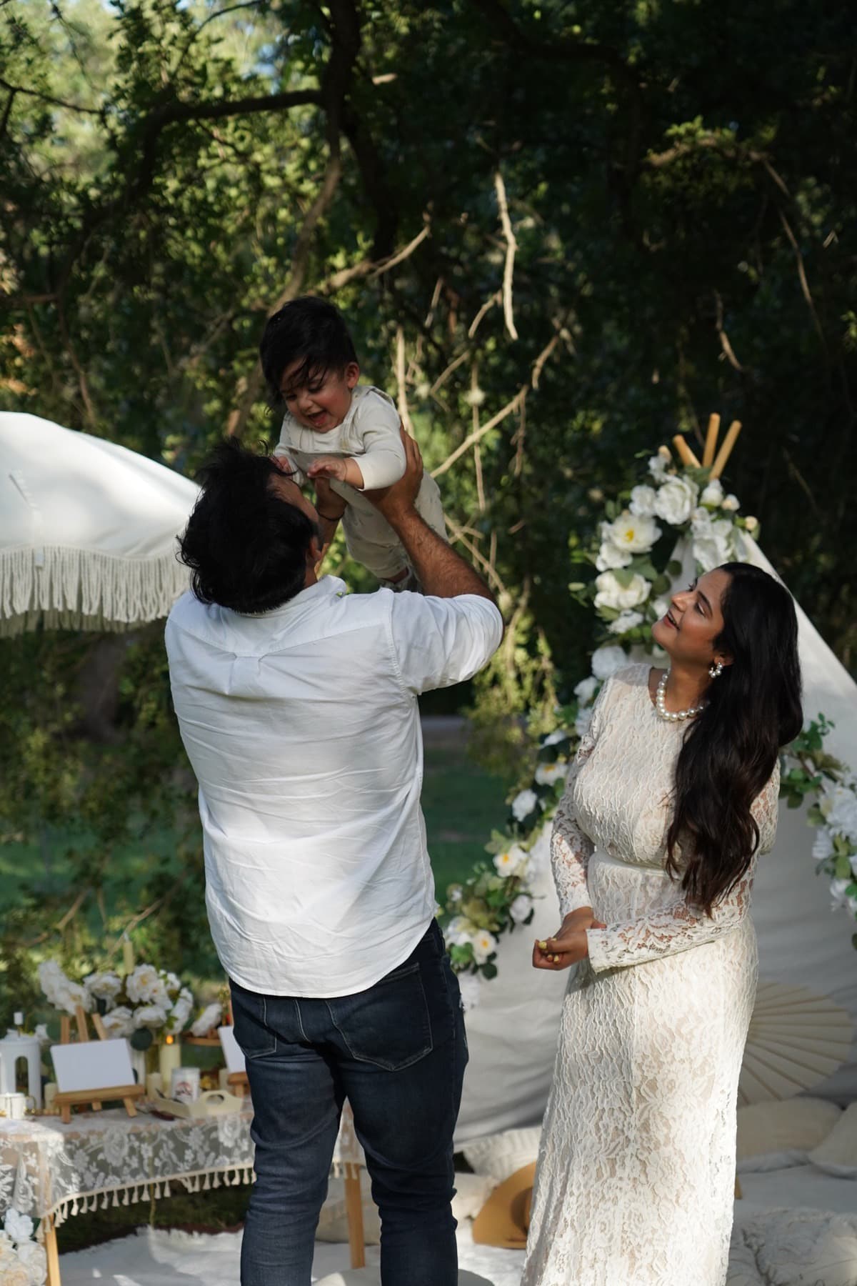 Familia celebrando junta en un pícnic boho con carpa de flores en Austin
